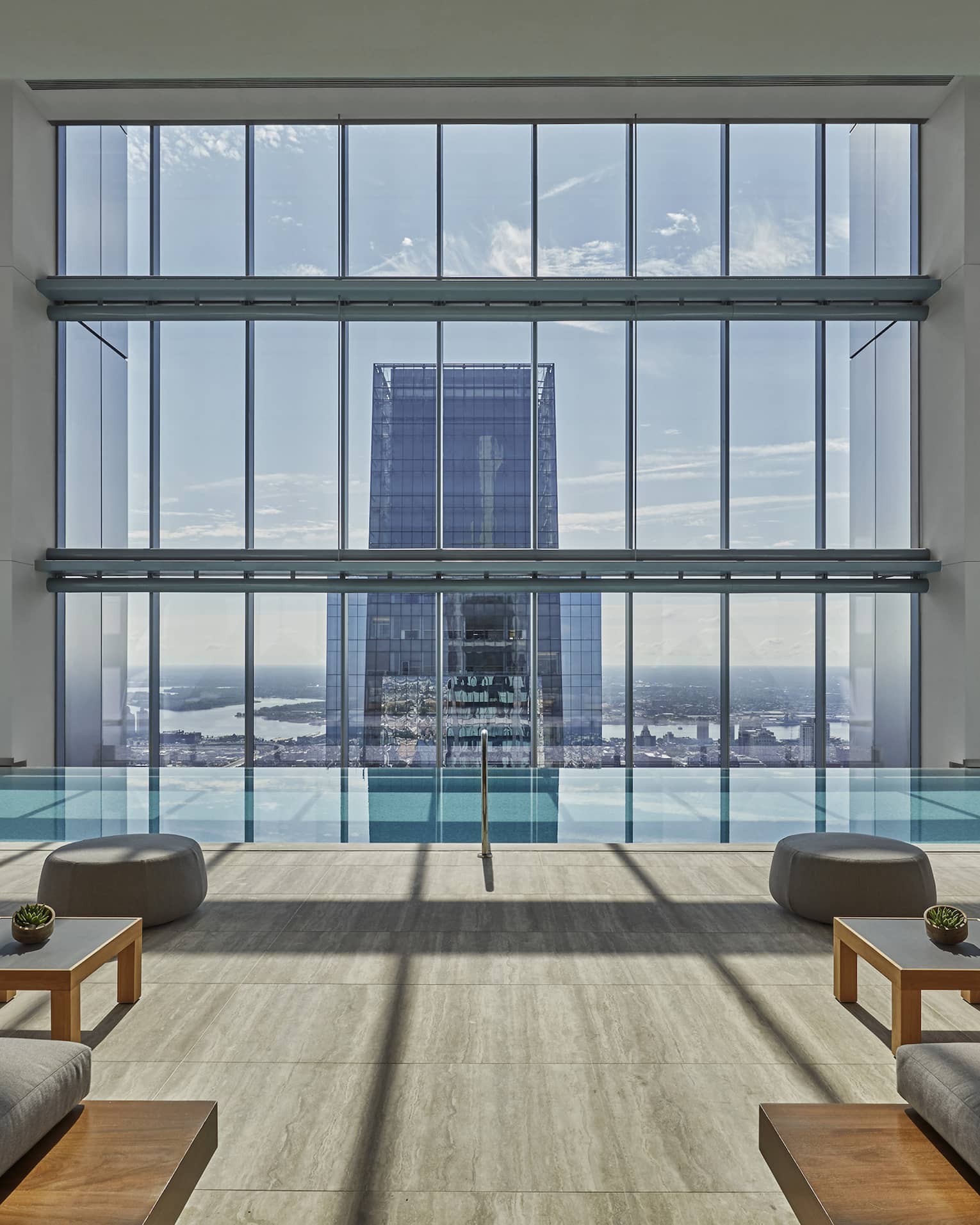Lounge sofas in front of spa pool under tall window