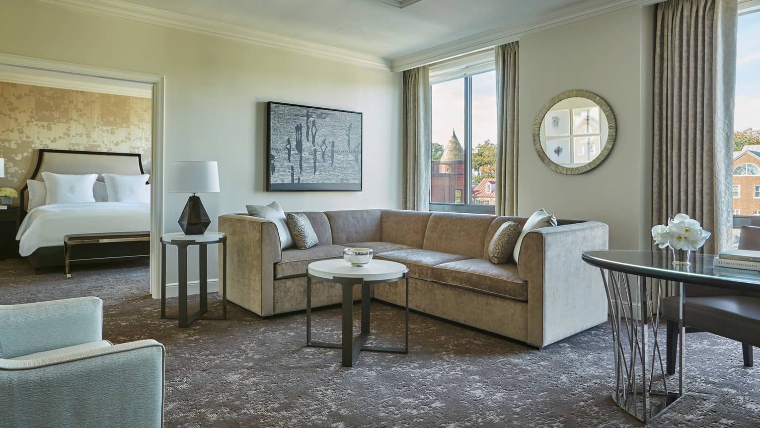 Georgetown One-Bedroom Suite L-shaped grey sofa between door to bedroom, large picture windows, work desk