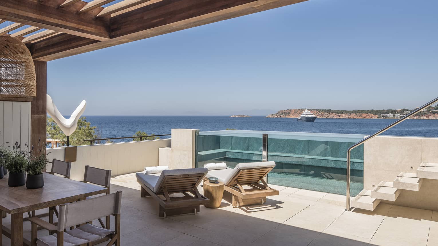 Suite with private pool, lounge chairs, dining table, stairs, ocean views