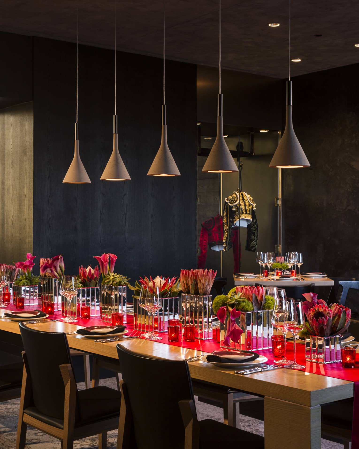Long table with red runner under row of lamps in San Sebastian private dining room