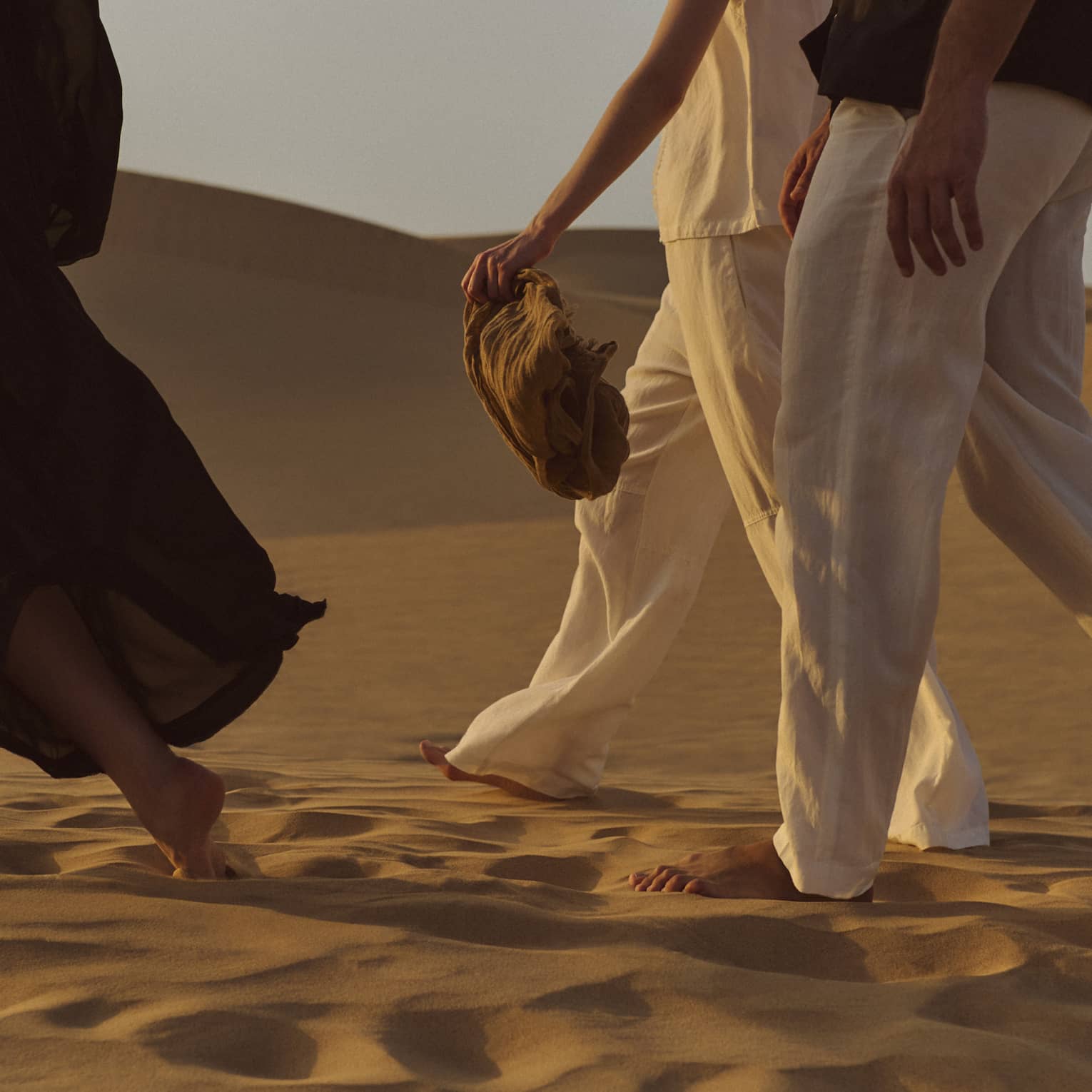 Three people walking in the dessert