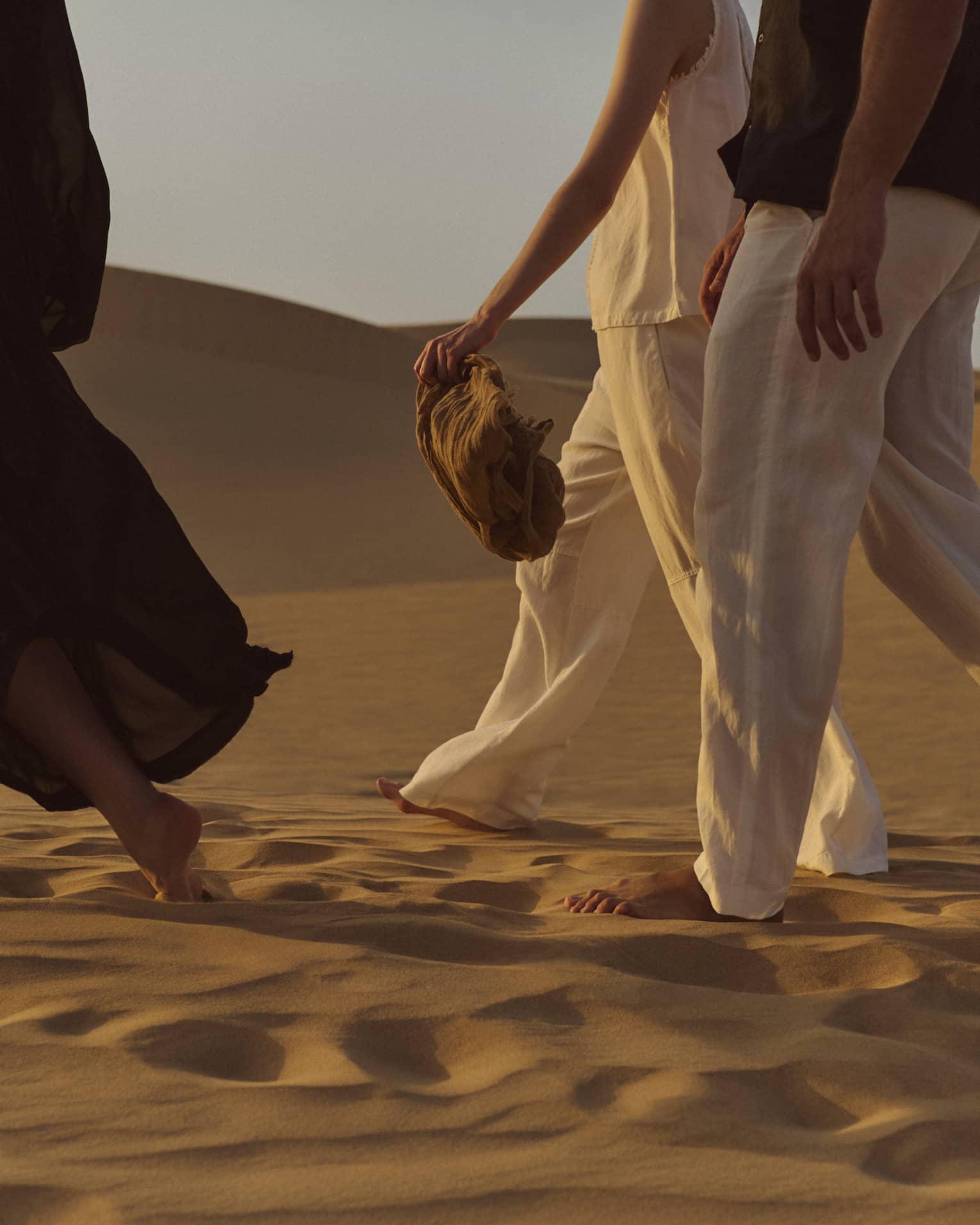 Three people walking in the dessert