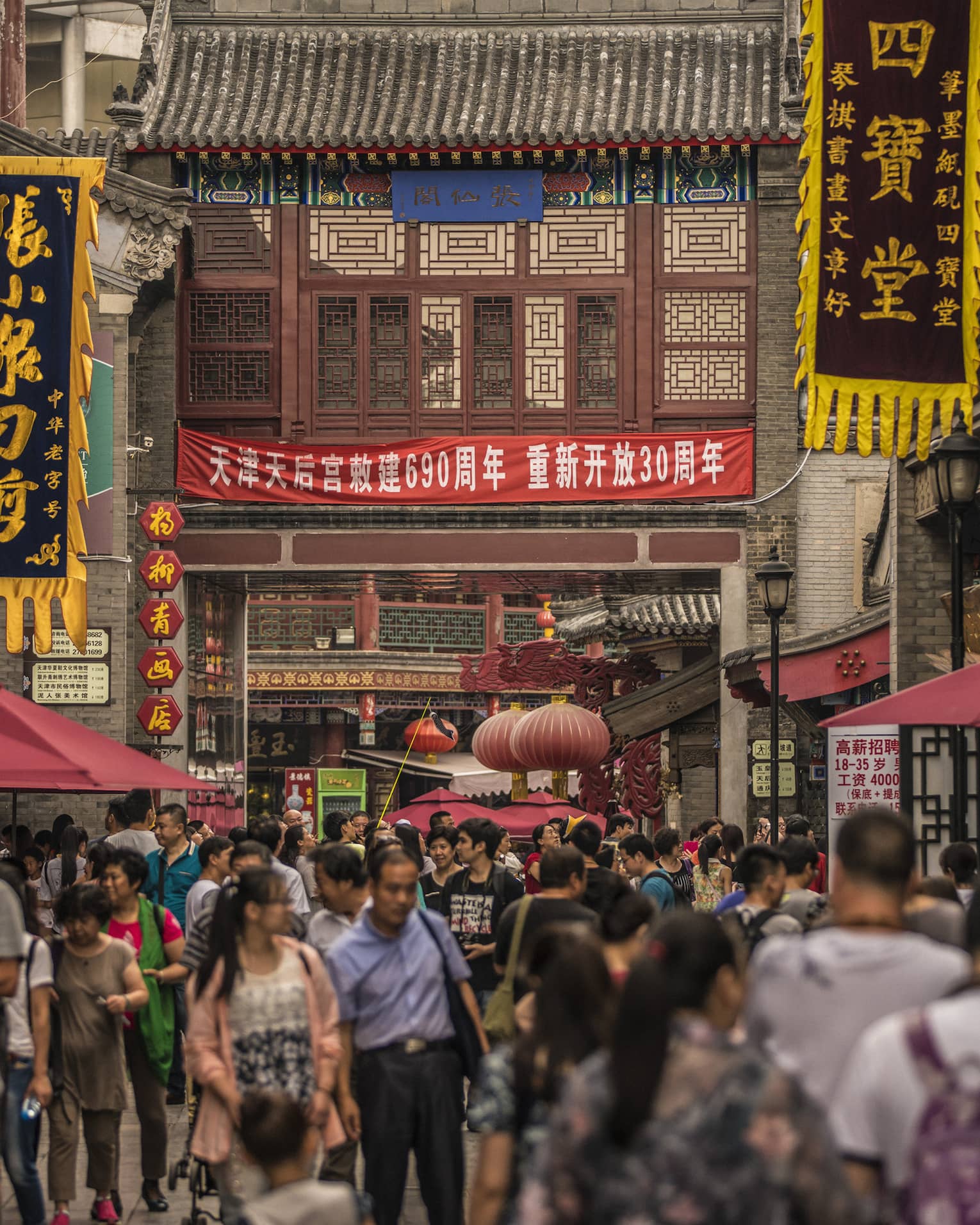 People walk through crowds on busy Tianjin street