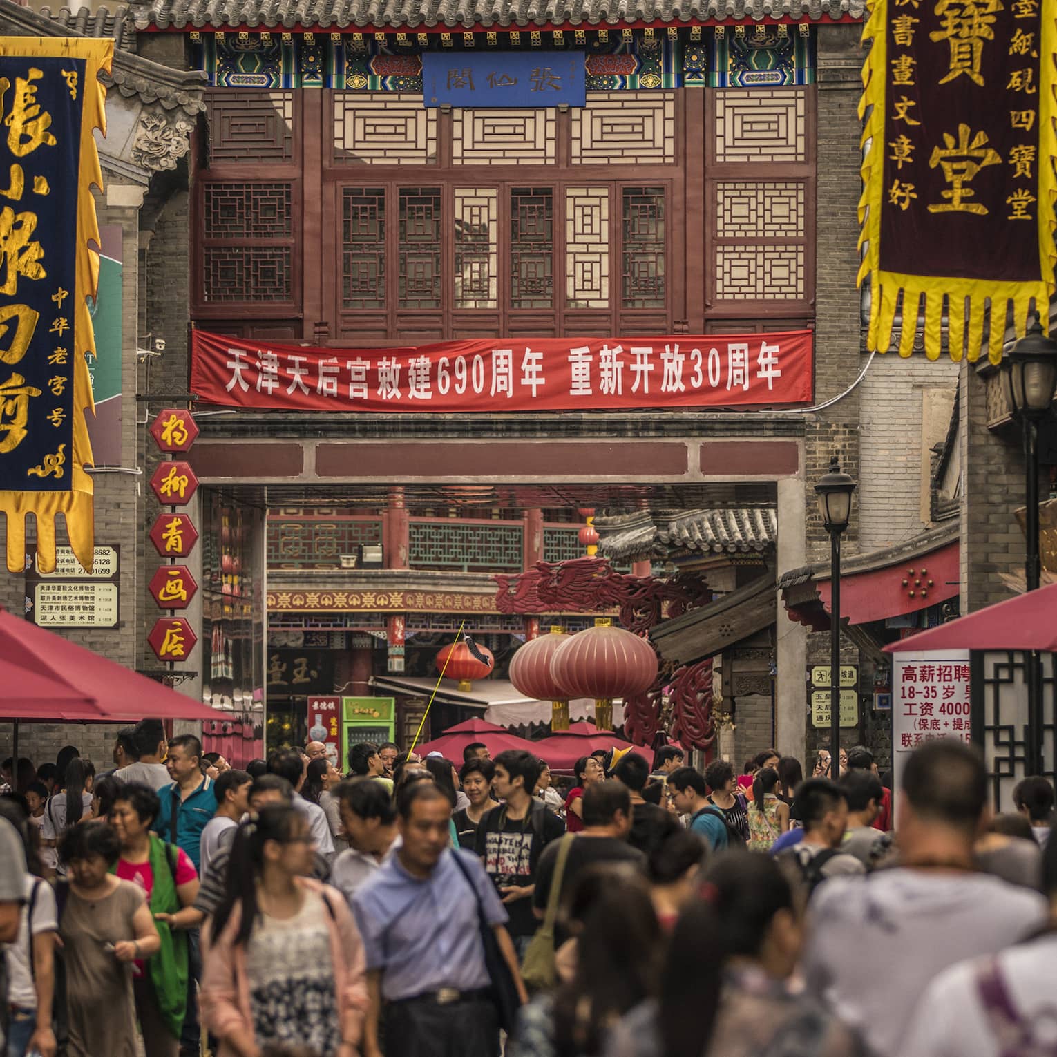 People walk through crowds on busy Tianjin street