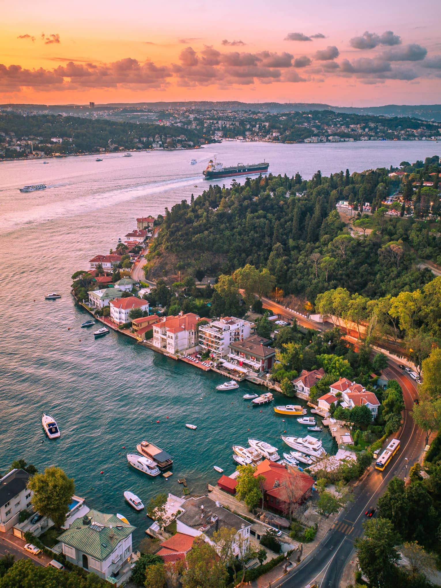 Aerial view of the river and parts of the city with a rosy sunset in the background.