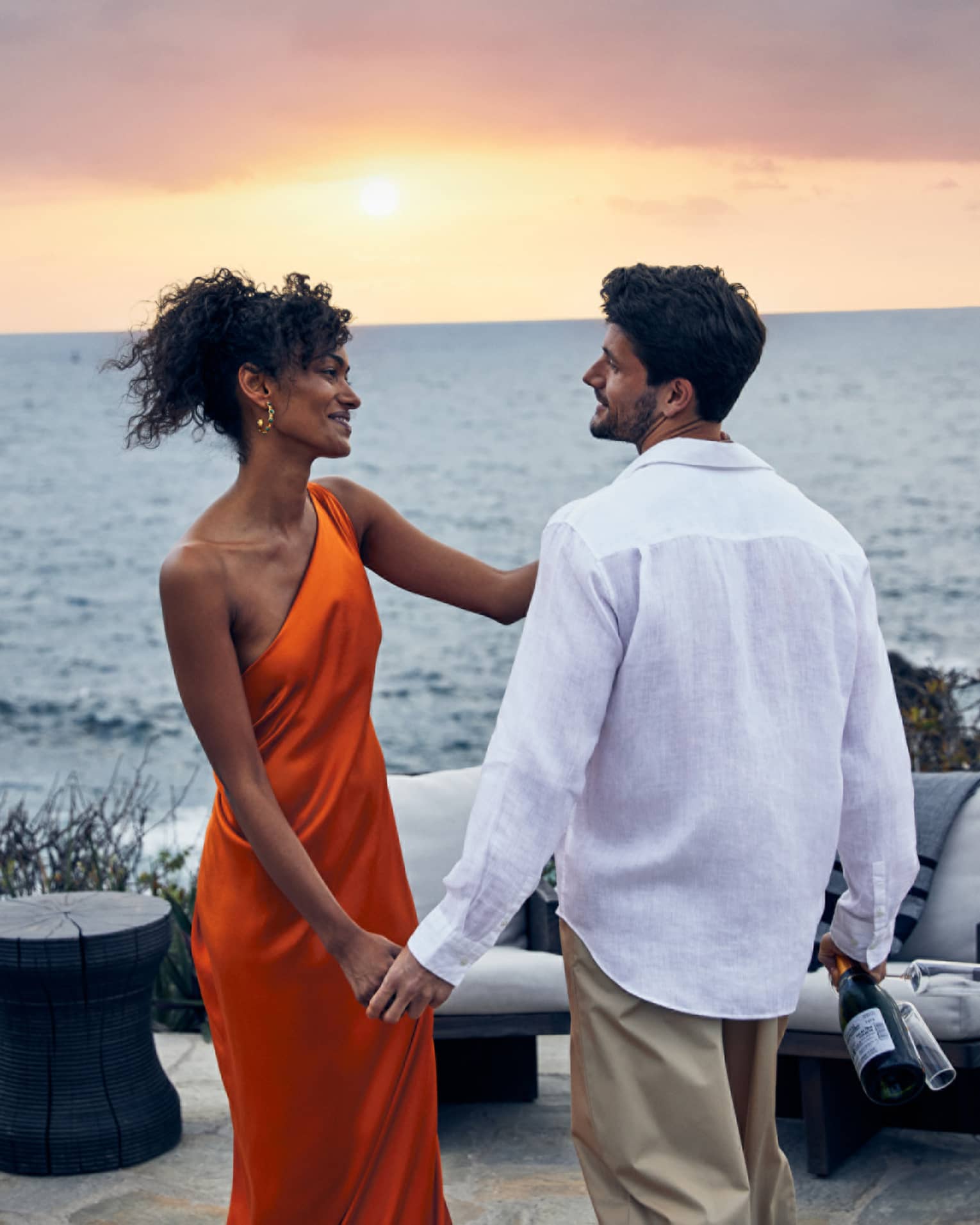A couple sharing a romantic sunset view over the ocean.