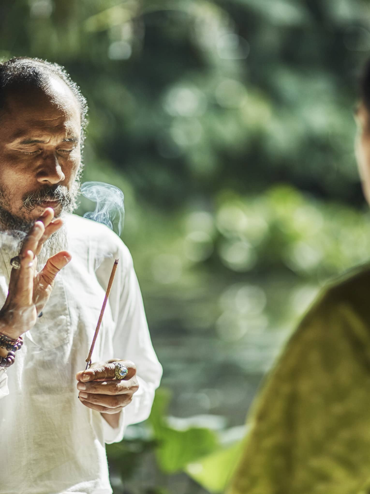 A healer holding a burning stick of incense