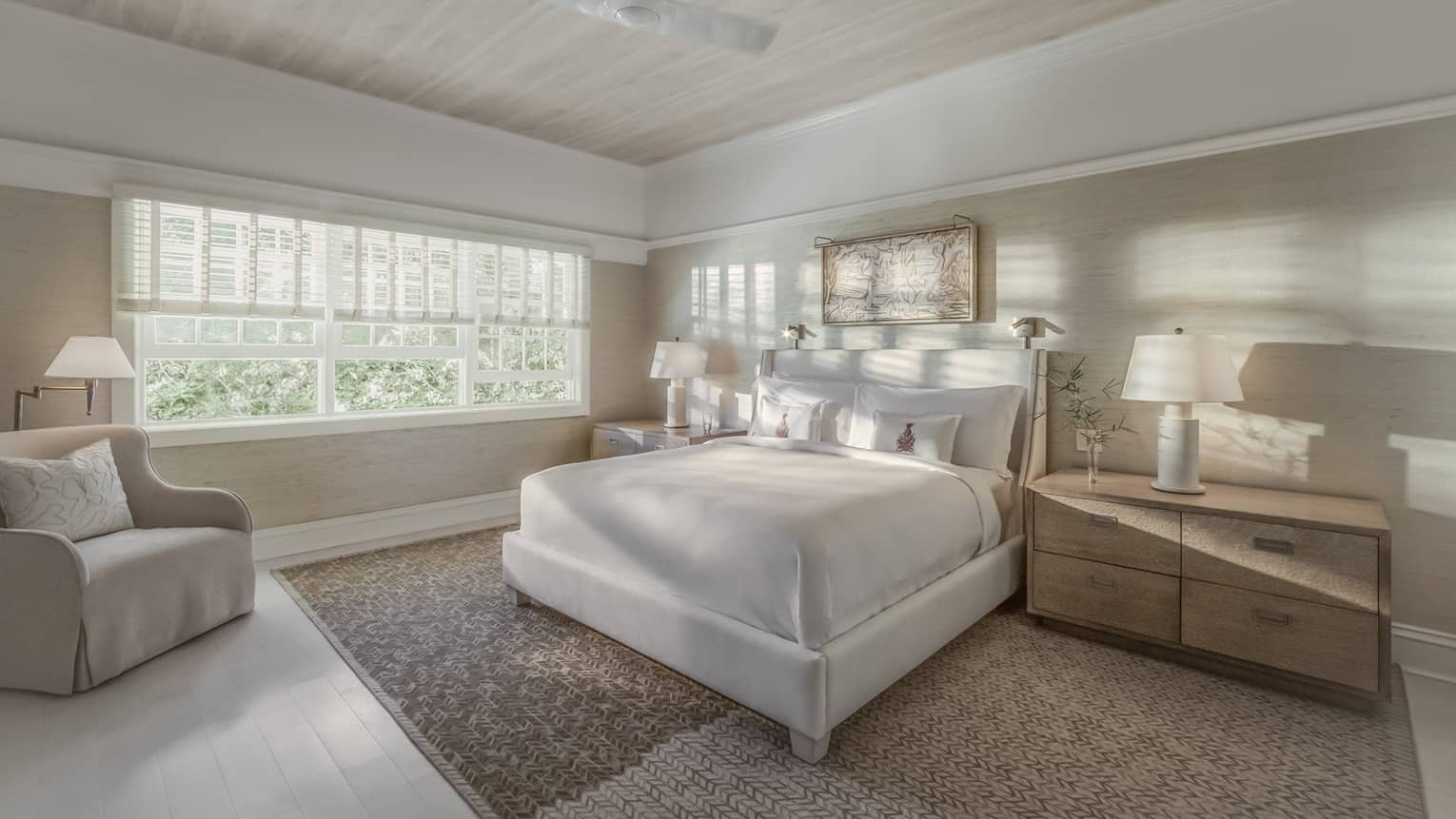 Sunlight and shadows shine through the window of a master suite bedroom