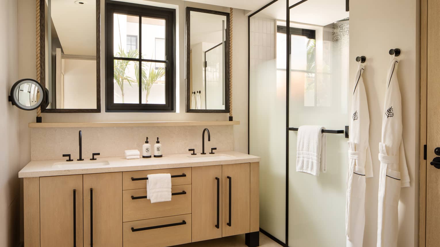 Luxury villa bathroom with window over a double vanity and a walk-in shower with frosted glass