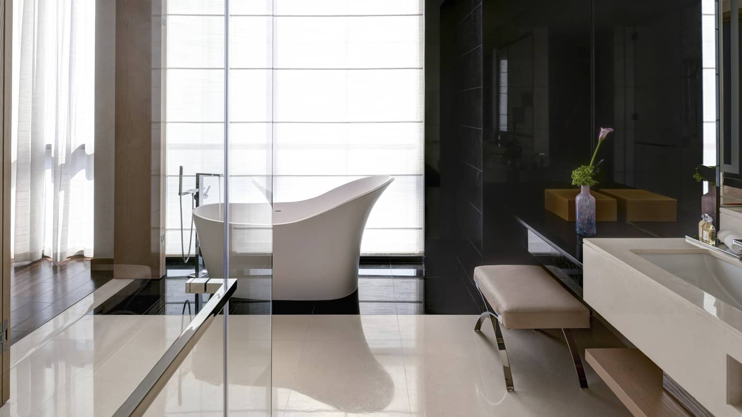 Bathroom with marble floors, glass shower, freestanding tub