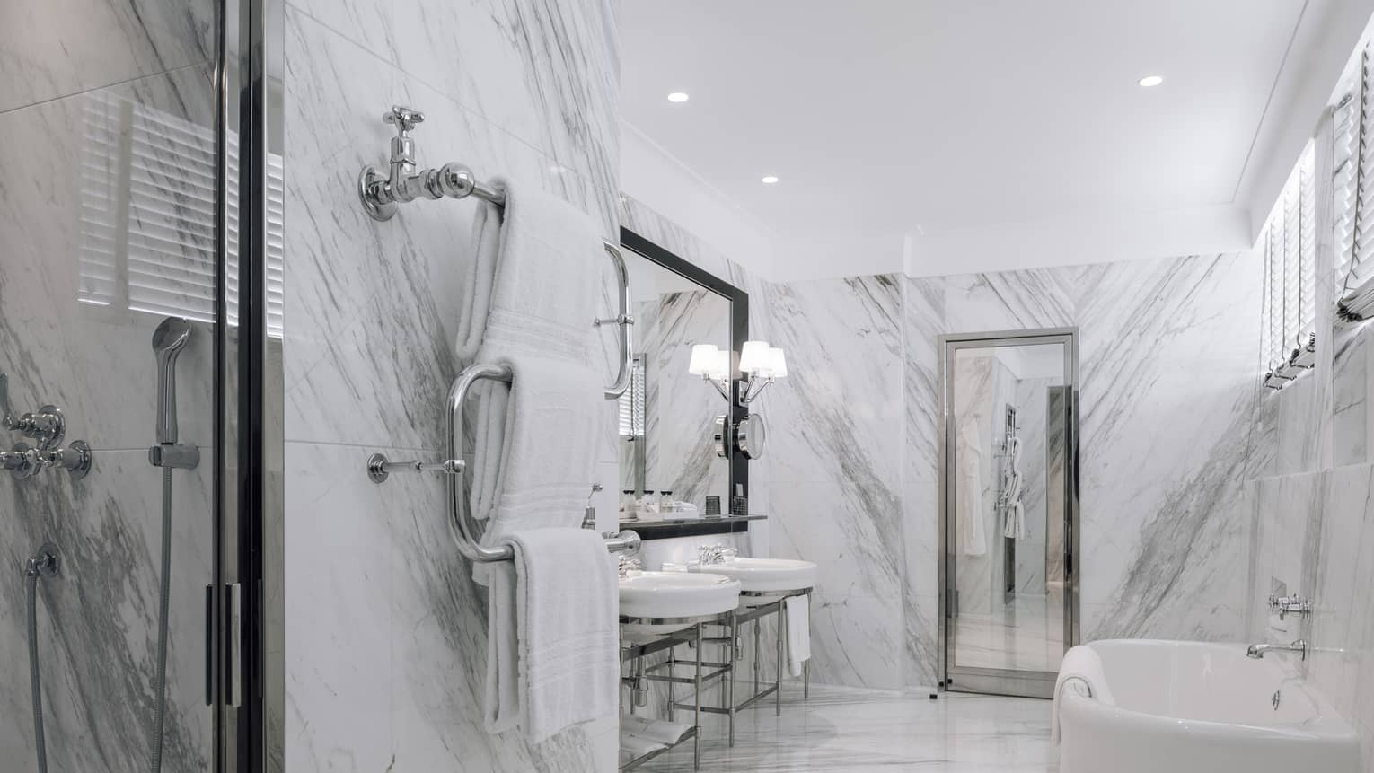 White and grey marble bathroom with two sinks, white tub, walk-in shower