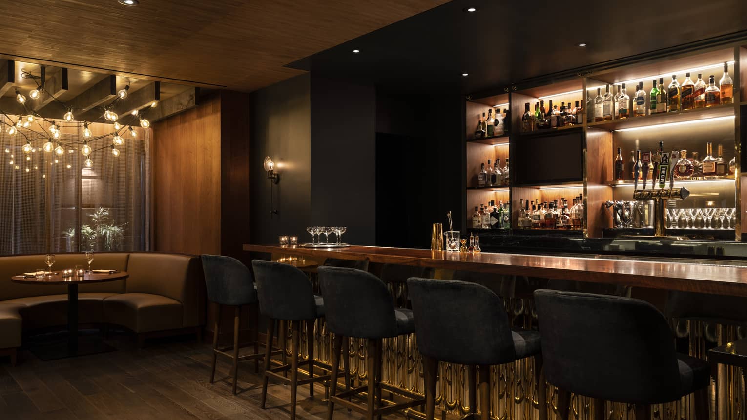A dimly lit bar with wood floor and paneling.