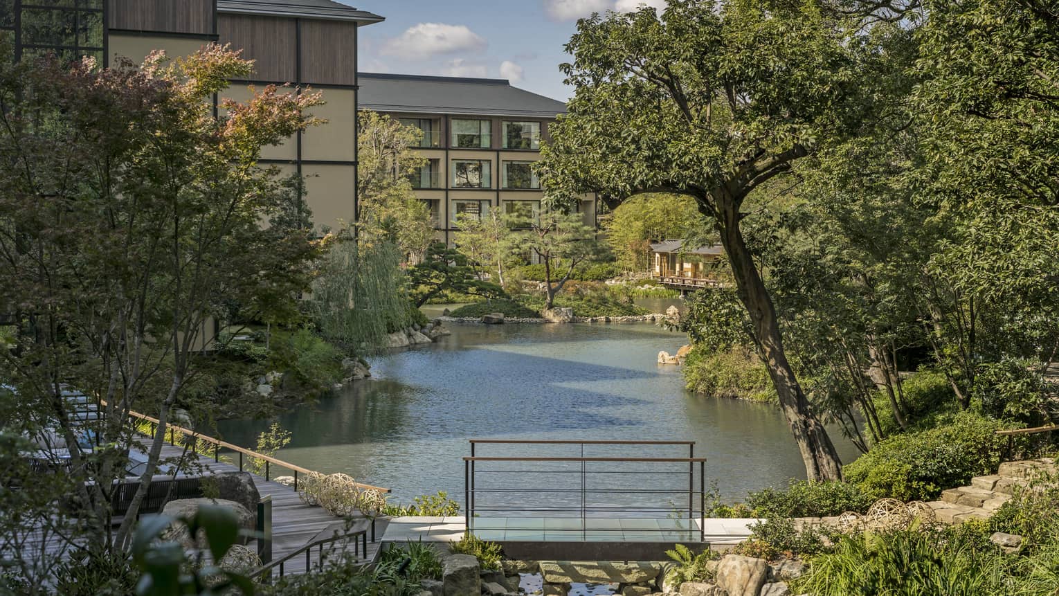 Trees, Shakusuien garden around pond under Four Seasons Hotel Kyoto building