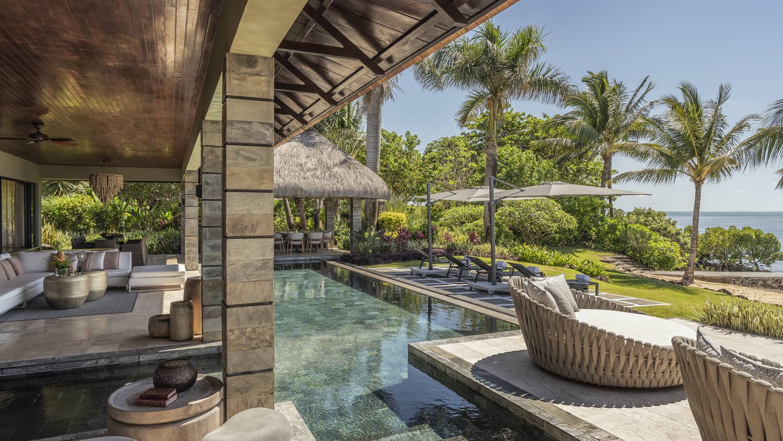 Stone, ocean-view terrace with pool, whicker day beds, pavilion covering