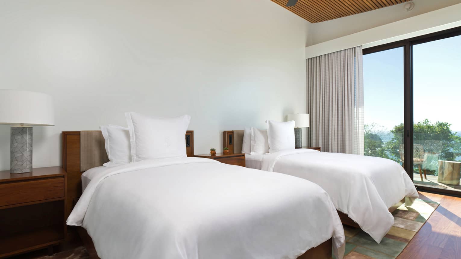 Bedroom with two beds and ocean-view balcony