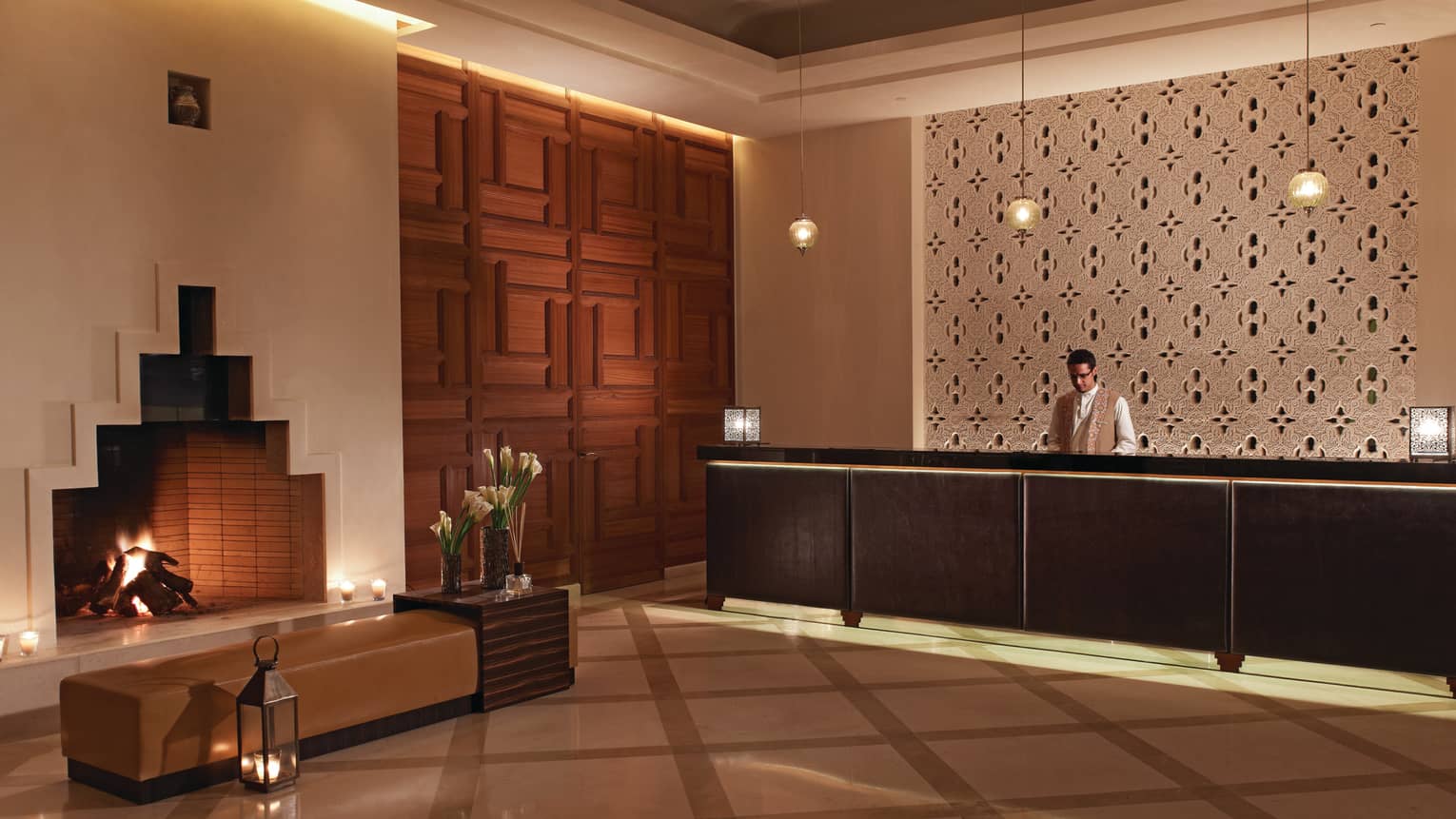 Four Seasons Resort Marrakech modern white hotel lobby with fireplace, bench, lanterns by reception desk