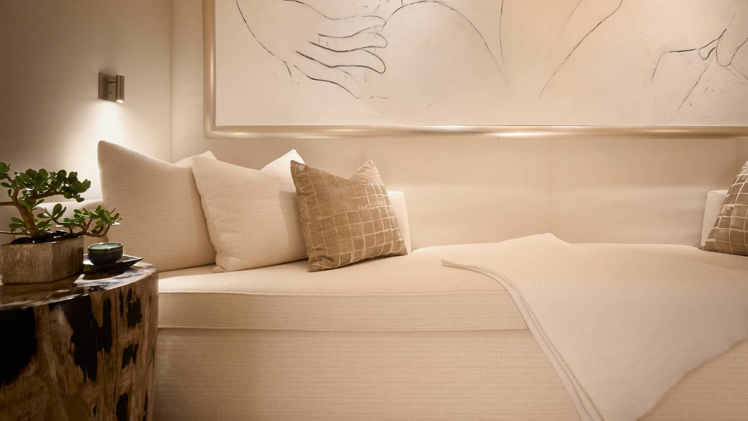 Plush white spa sofa with cushions on large framed print