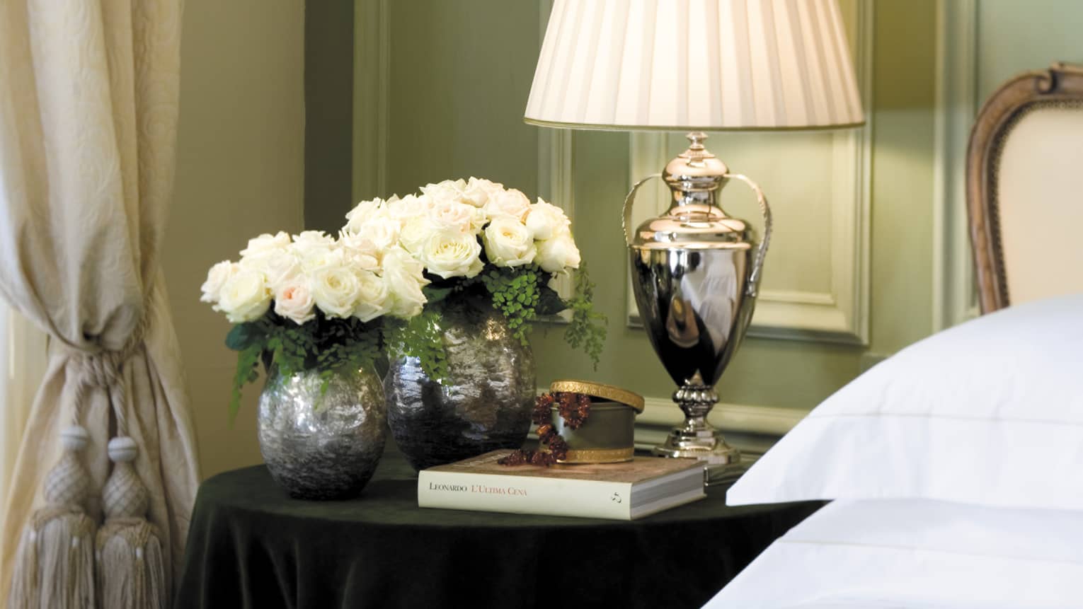 Superior Room silver lamp, vases with white roses, book on nightstand