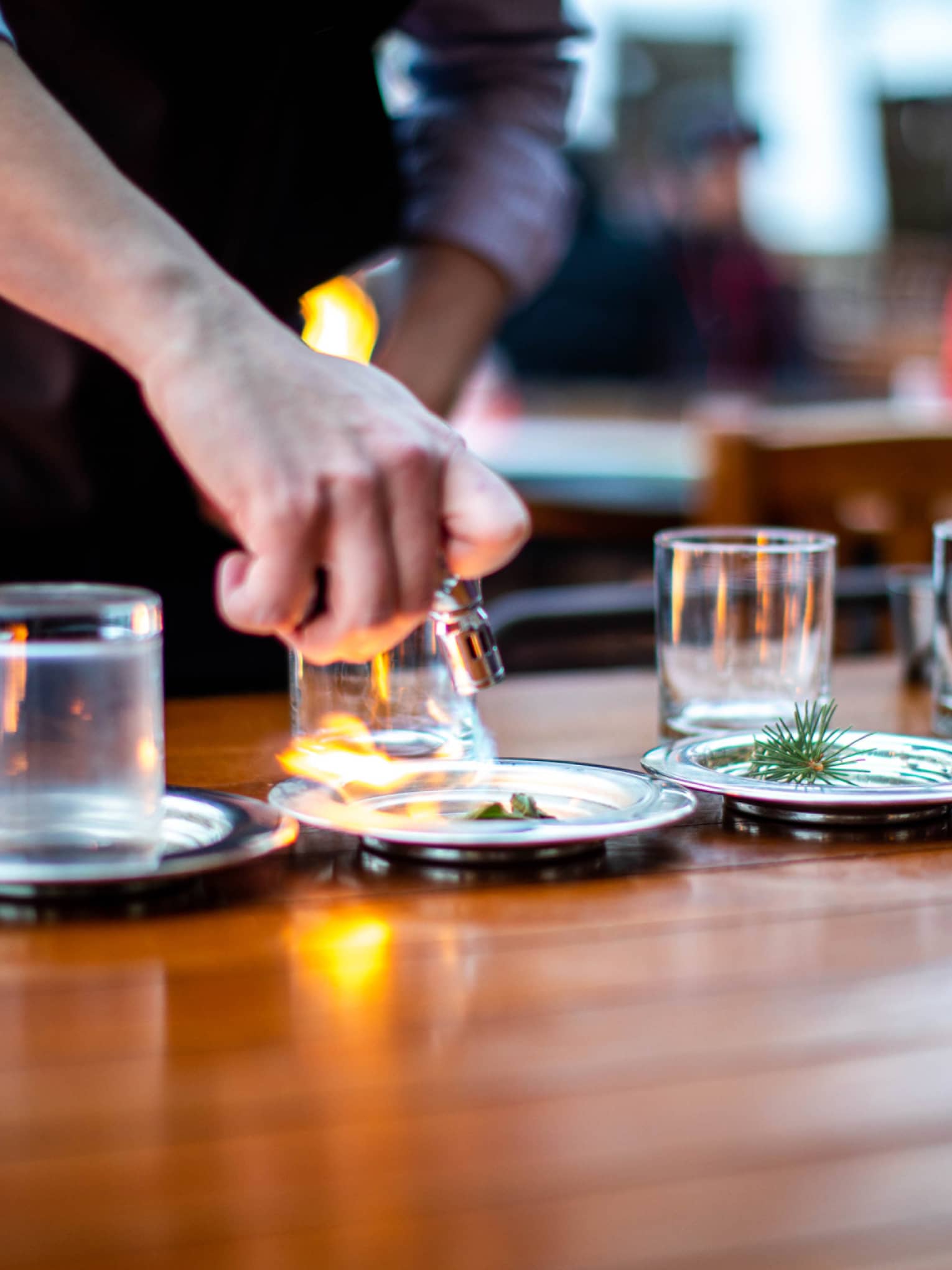 A mixologist burns ingredients as he prepares specialty whisky drinks