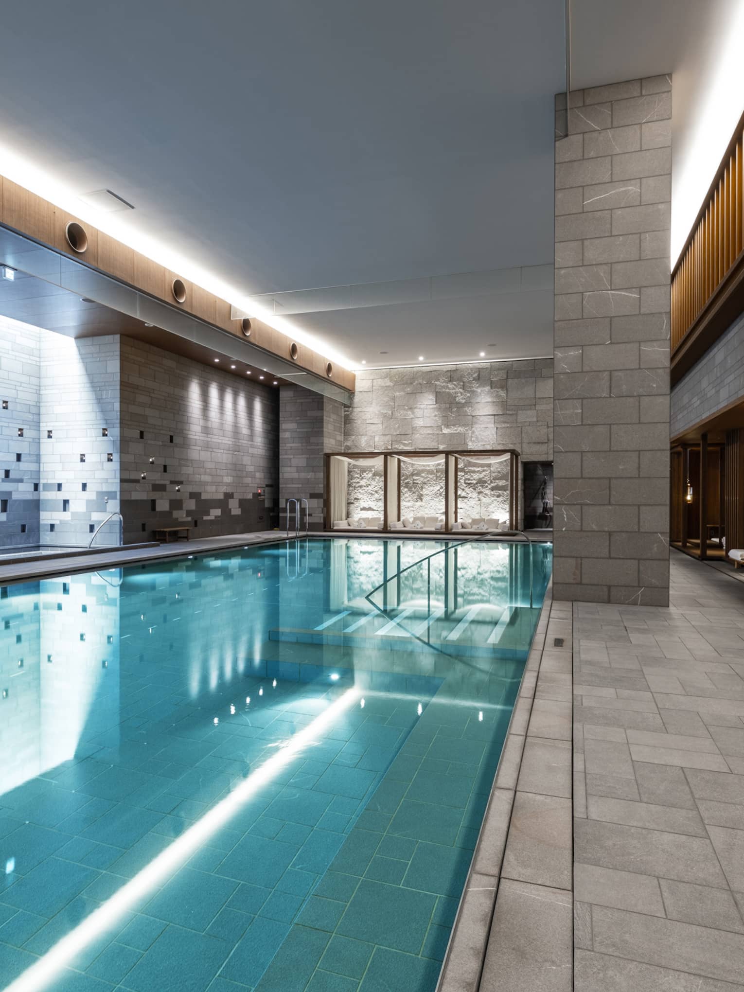 Indoor spa pool with chaise longues and grey columns