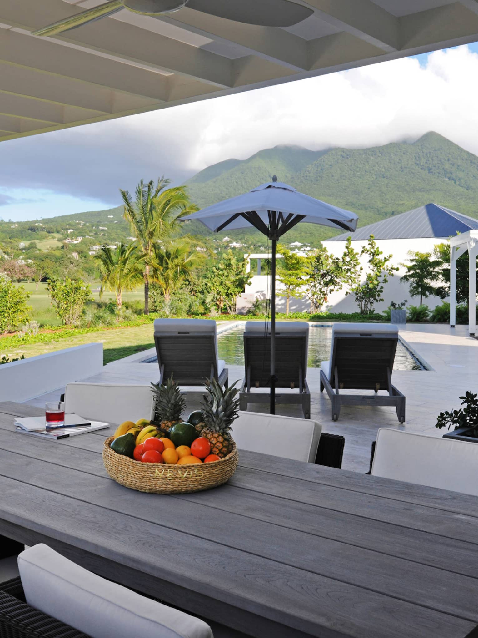 Pinney's Beach Residence Villa long patio dining table, wicker bowl with fruit