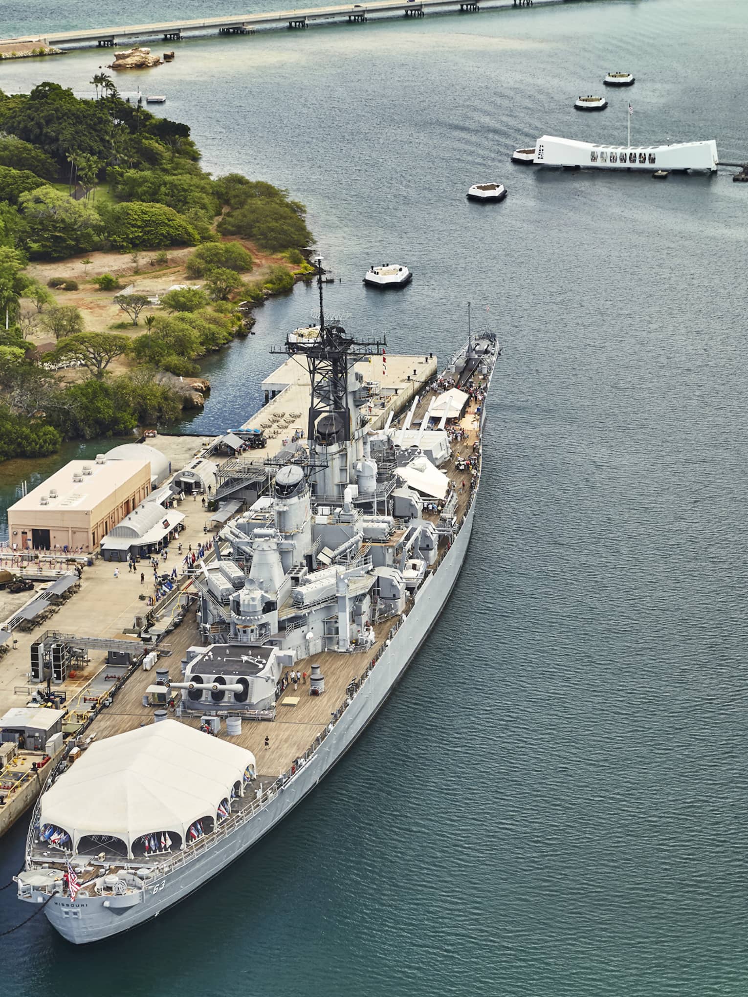 Aerial view of large battleship, people on dock at Battleship Missouri Memorial at Pearl Harbor