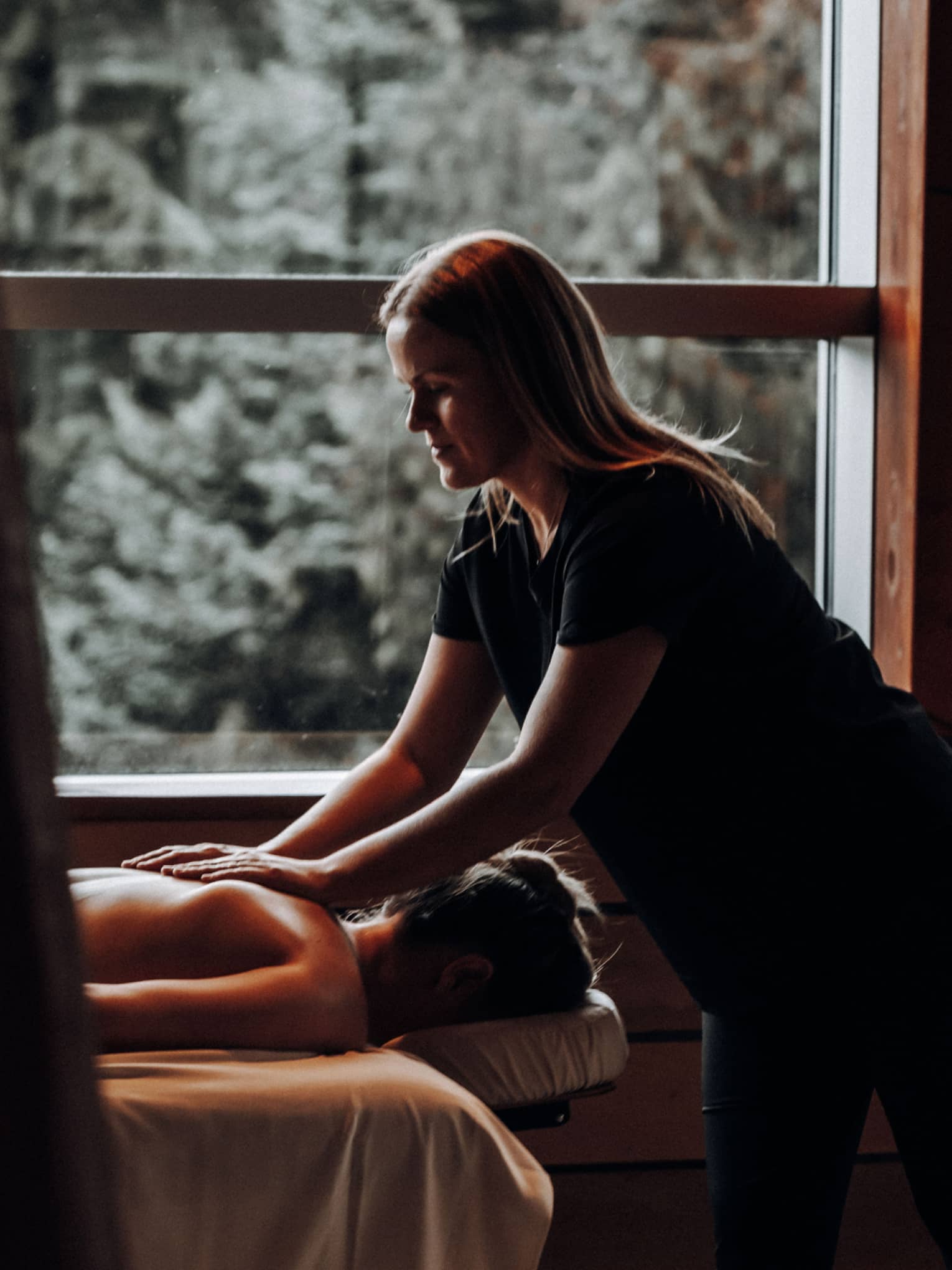 A woman receicing a massage in a dimly lit room.