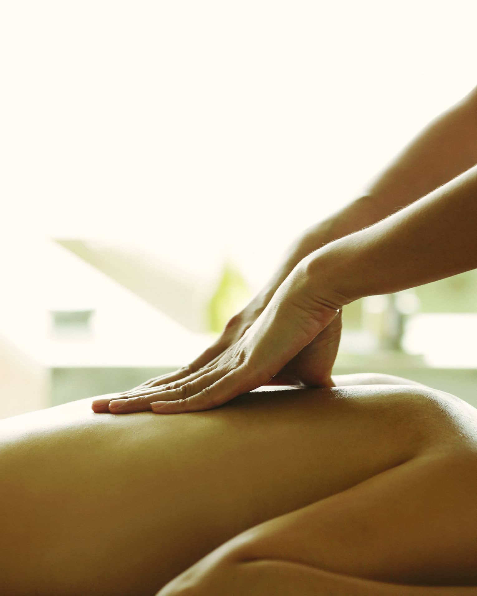 Close-up of a person receiving a relaxing back massage in a spa setting.