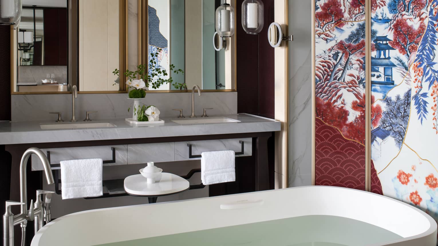 Luxury hotel suite bathroom with standalone tub and colourful Chinese wall art, at Four Seasons Hotel Suzhou