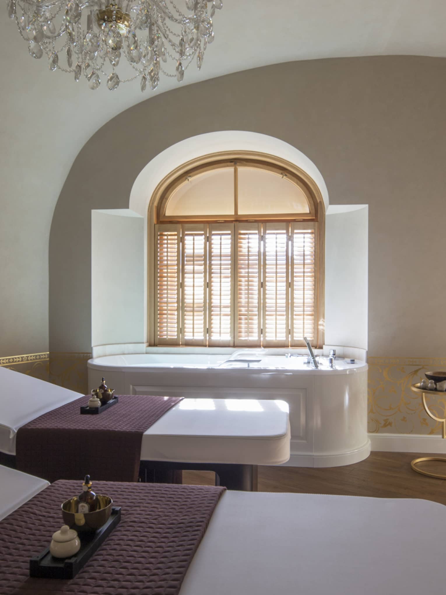 Two white beds beside spa tub in dimly-lit room at the Vltava Suite at AVA Spa