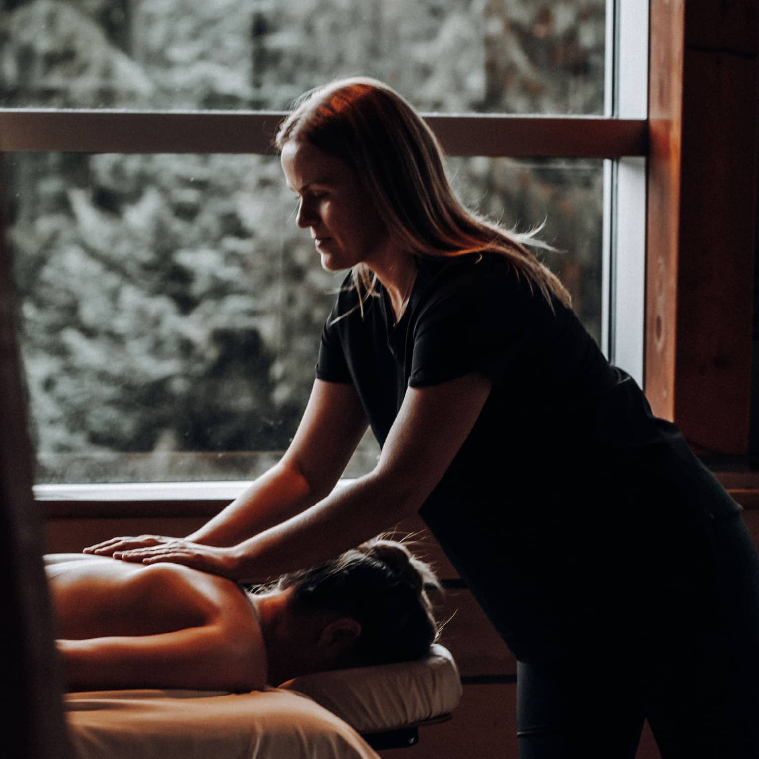 A woman receicing a massage in a dimly lit room.
