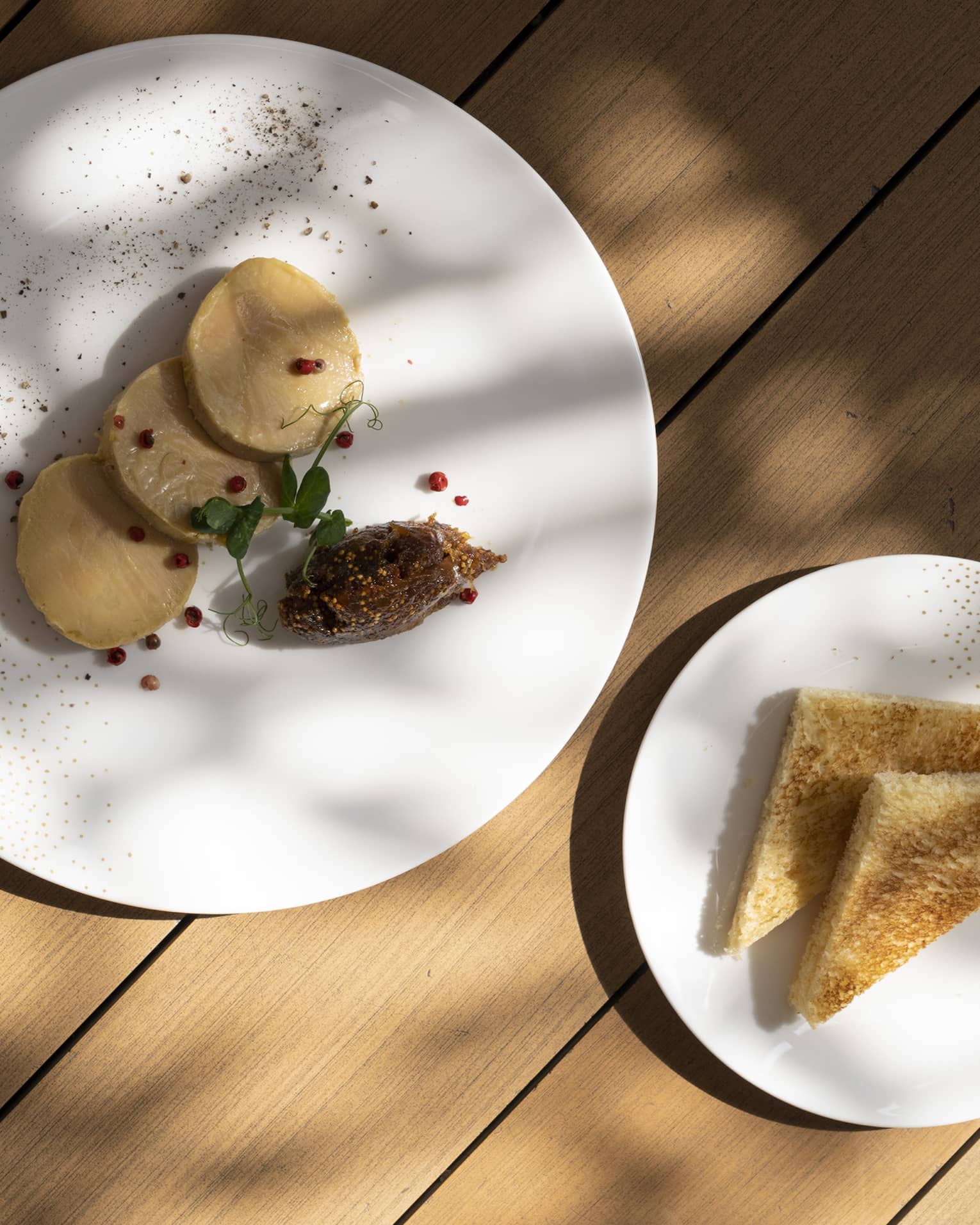 Two plates with toast and pancakes, and a red sauce.
