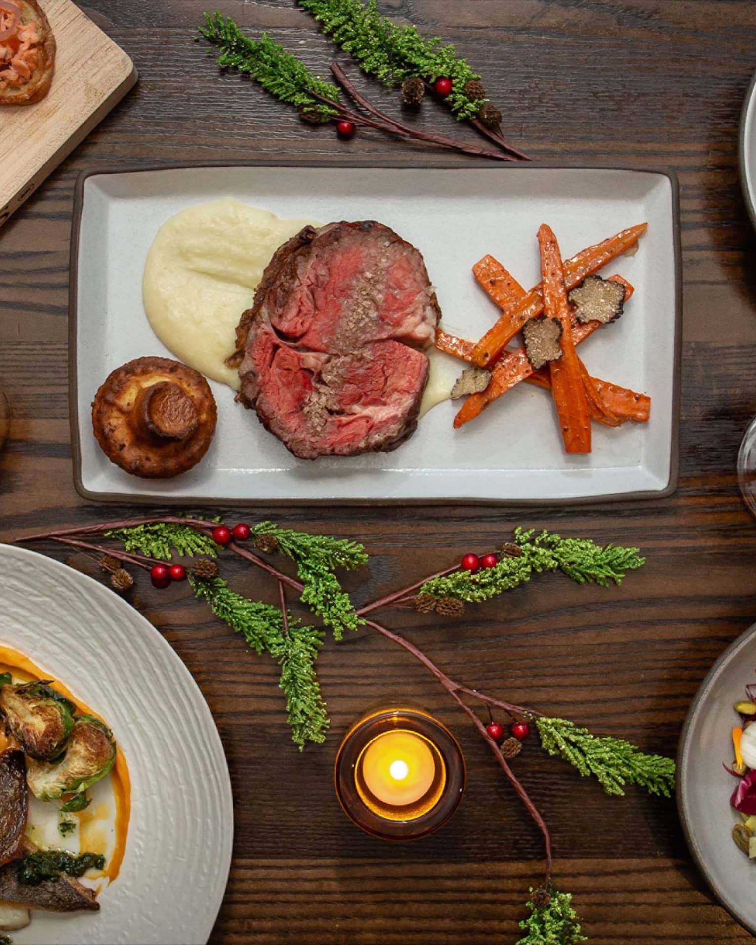 An assortment of holiday food on white and wood trays.