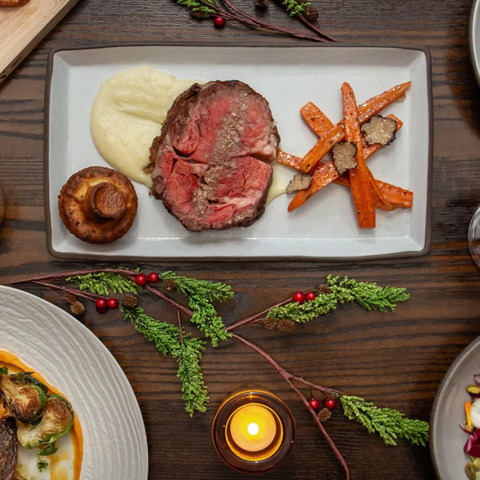An assortment of holiday food on white and wood trays.