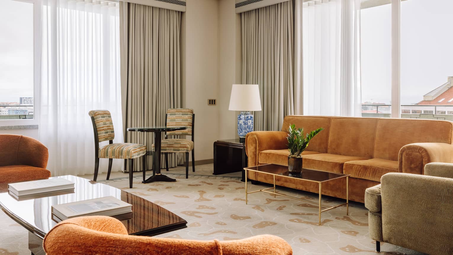 Living room with tan sofa, two arm chairs and windows