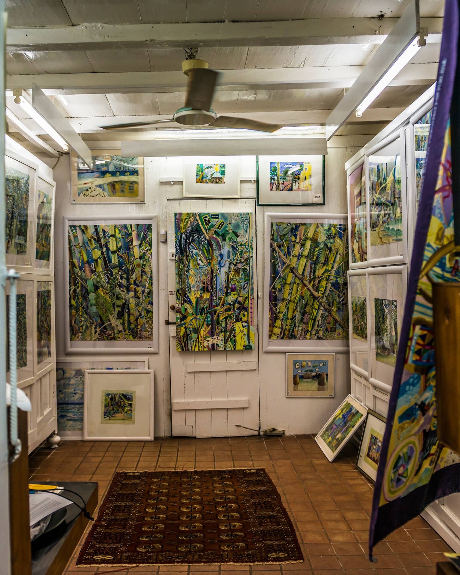 Interior of Michael Adams Gallery with colourful paintings on white walls 