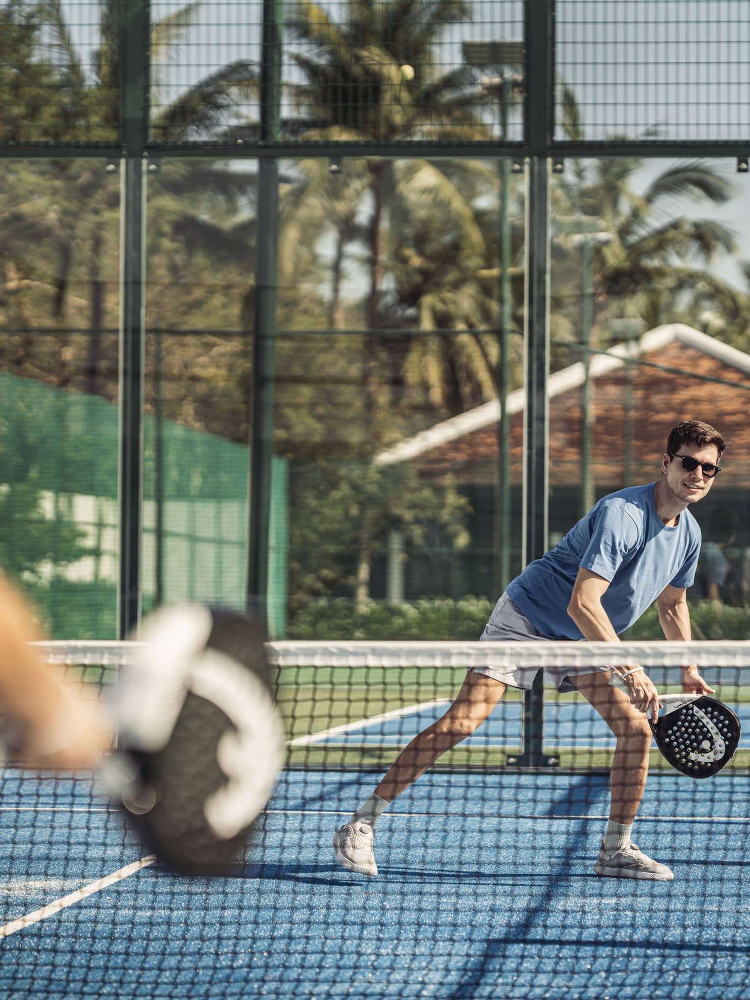 Couple plays paddleball on artificial turf court