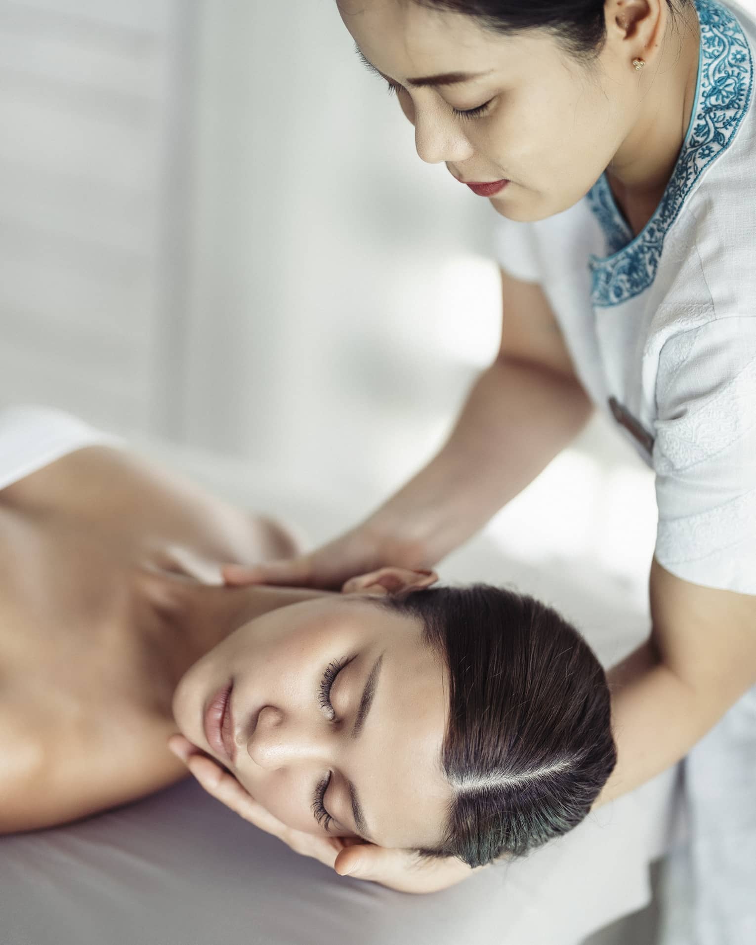 A woman in a spa receiving chiropracty.