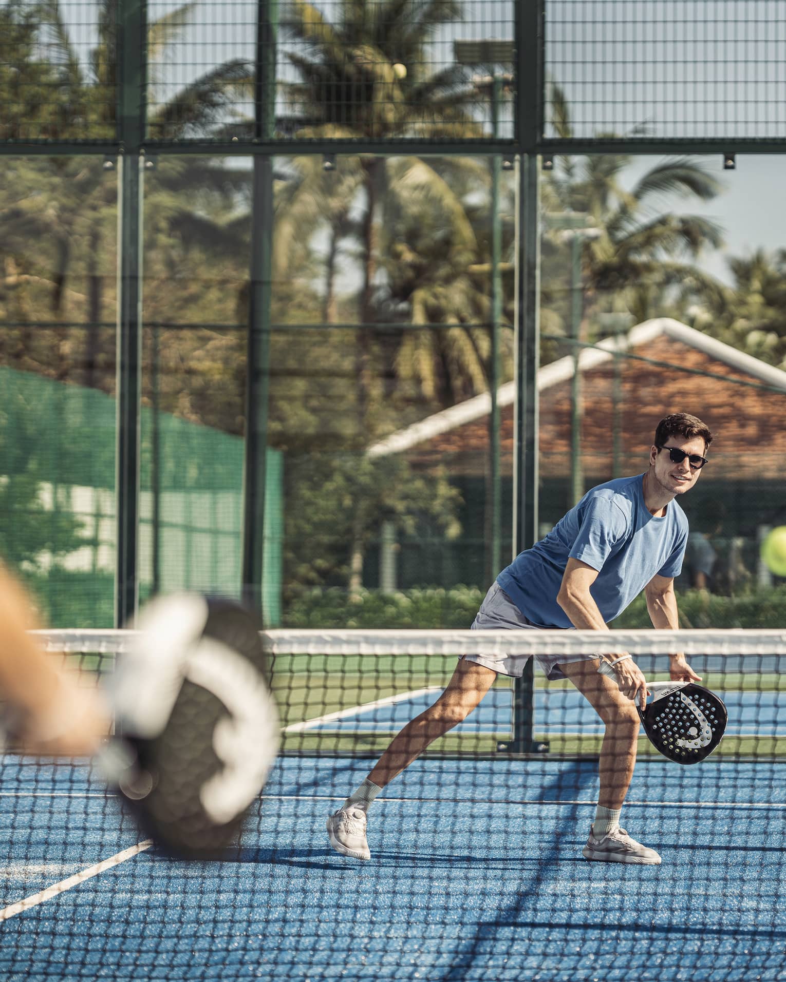 Couple plays paddleball on artificial turf court