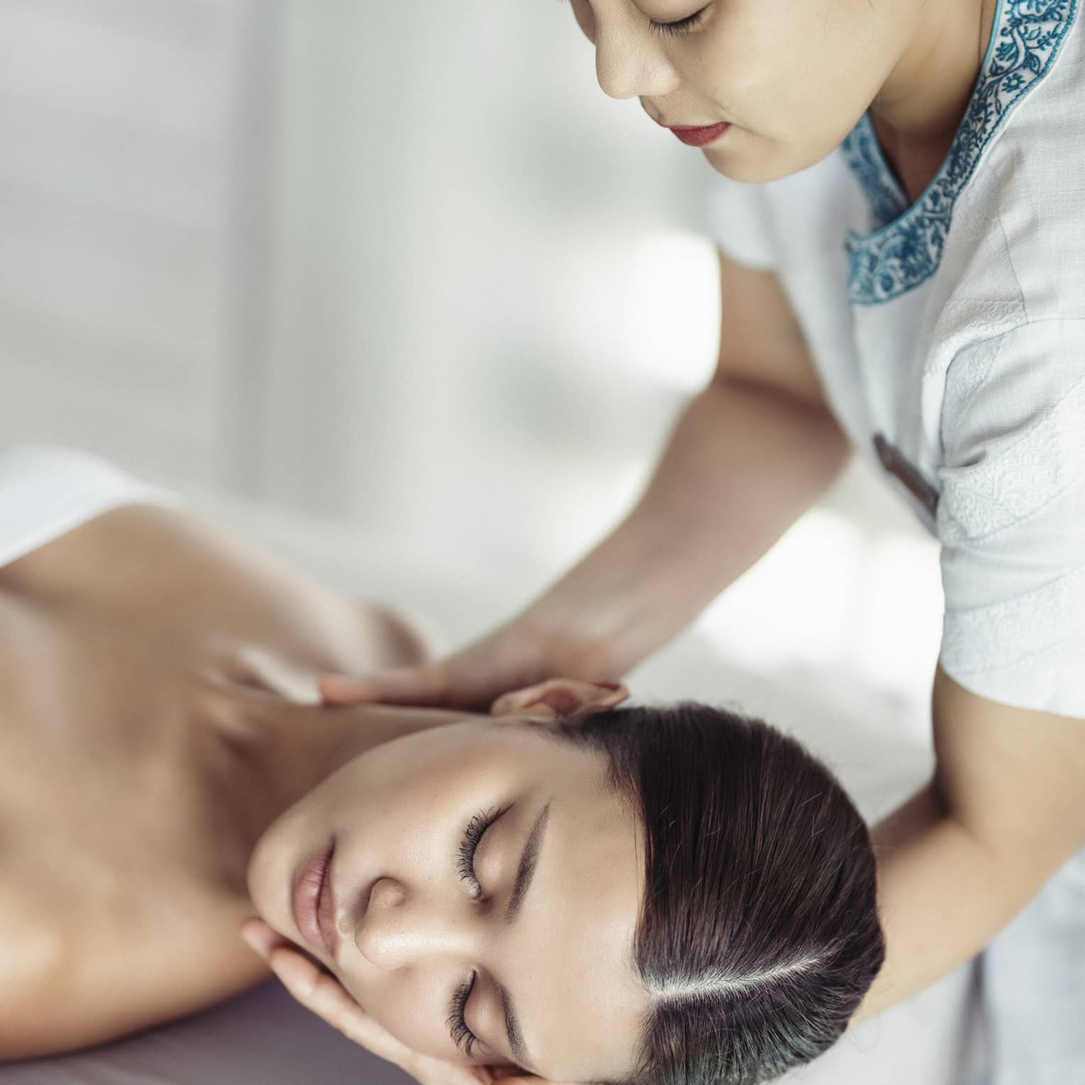 A woman in a spa receiving chiropracty.