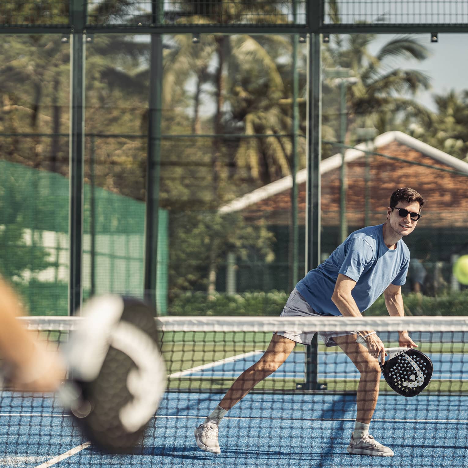 Couple plays paddleball on artificial turf court