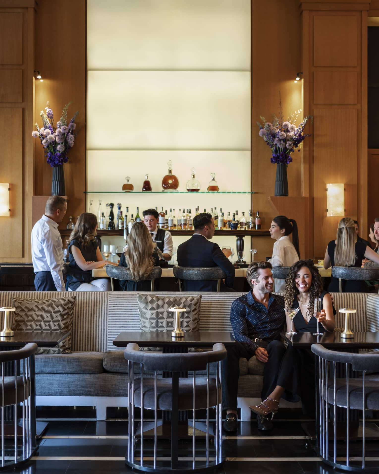 People sitting at a bar and booth in a dining outlet.