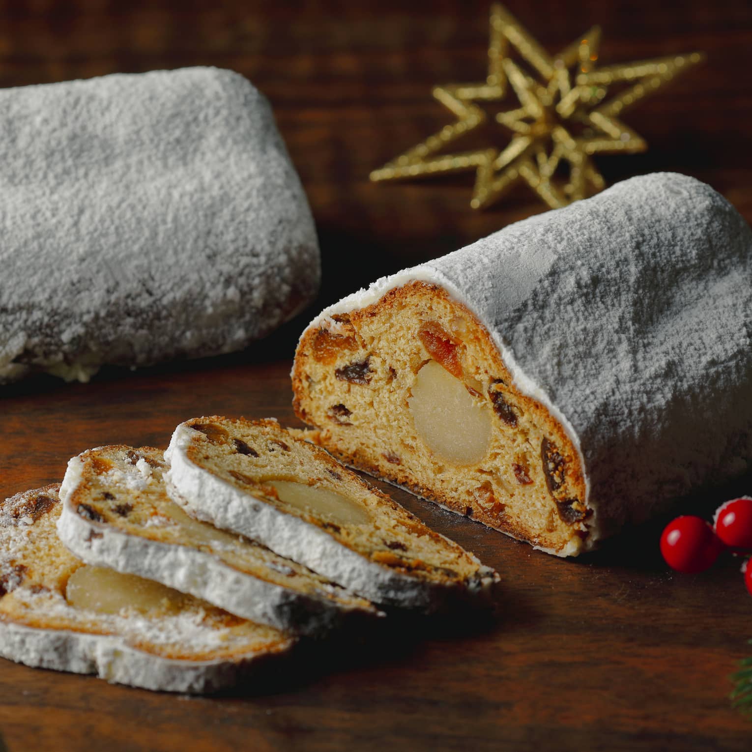 Stollen, sliced on a wooden table with festive decor