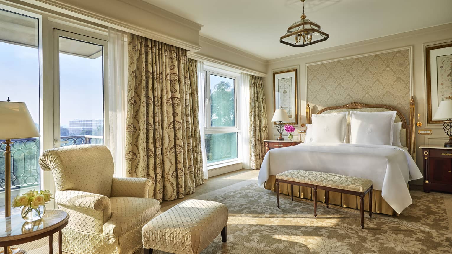 Diplomatic Suite with soft beige and cream decor, bed and club chair with ottoman