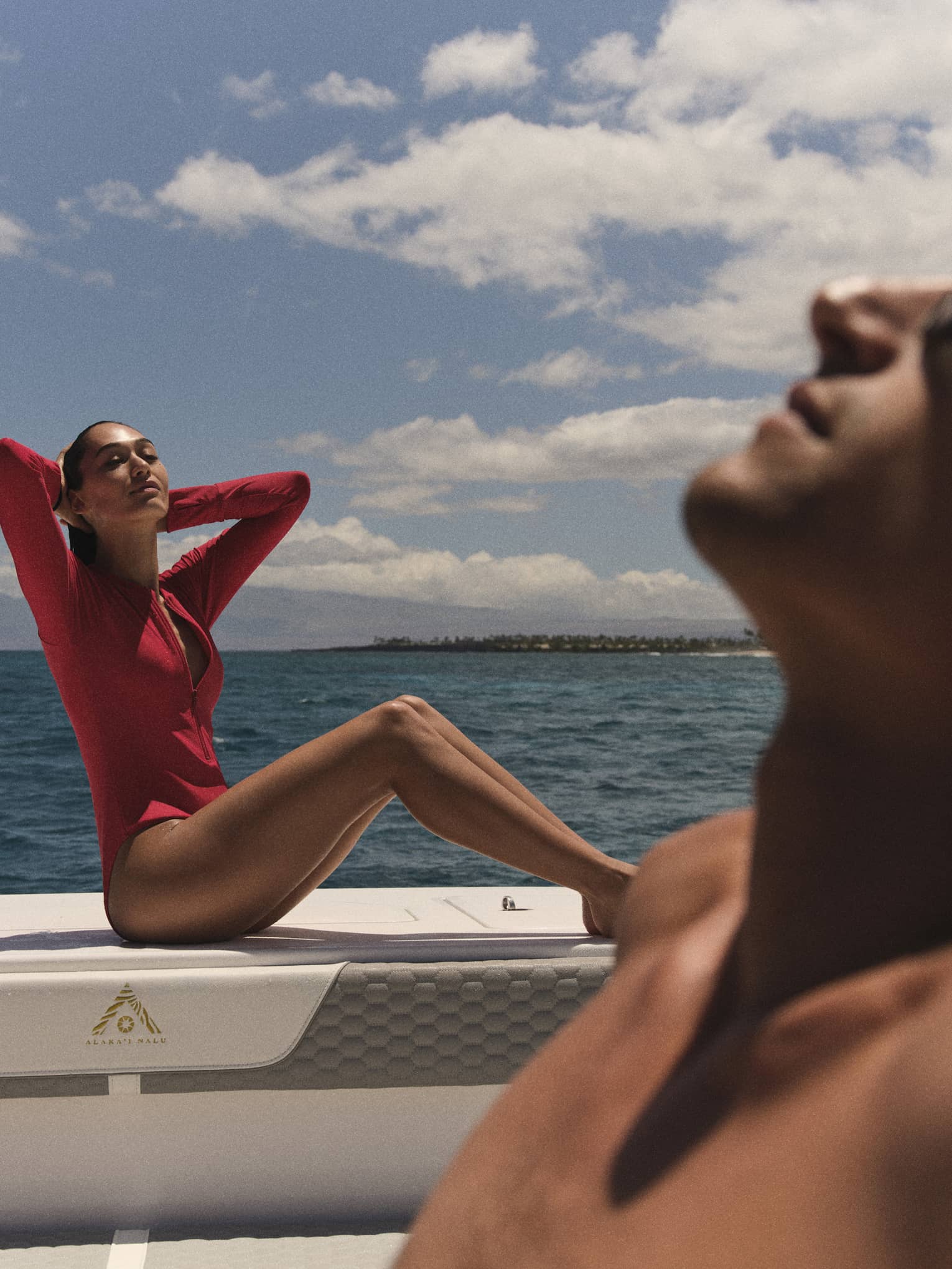 Two people sun tan on a boat at sea