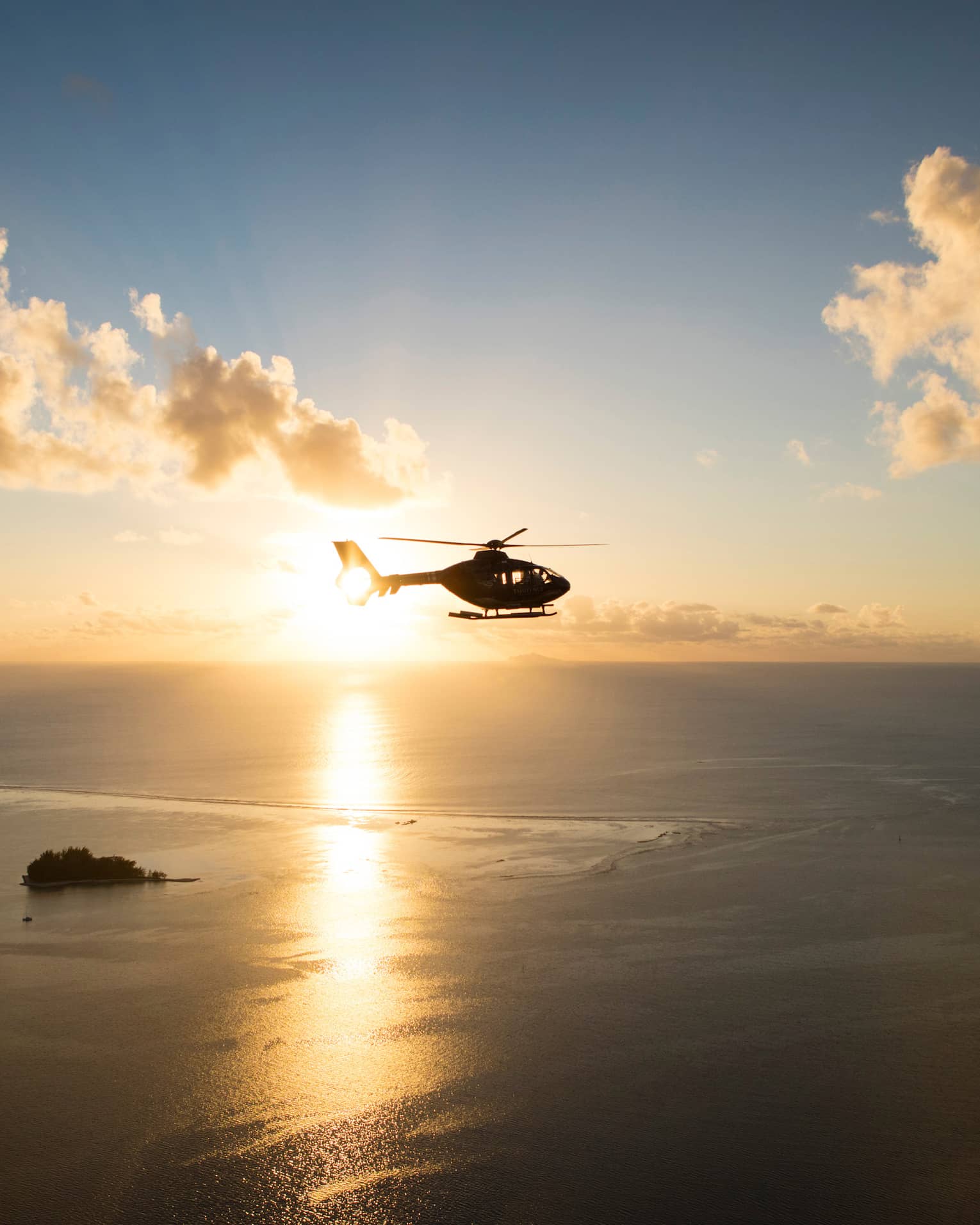 Helicopter over the sea at sunset
