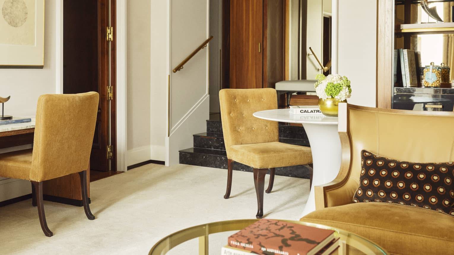 Hotel suite with gold-coloured desk and dining chairs
