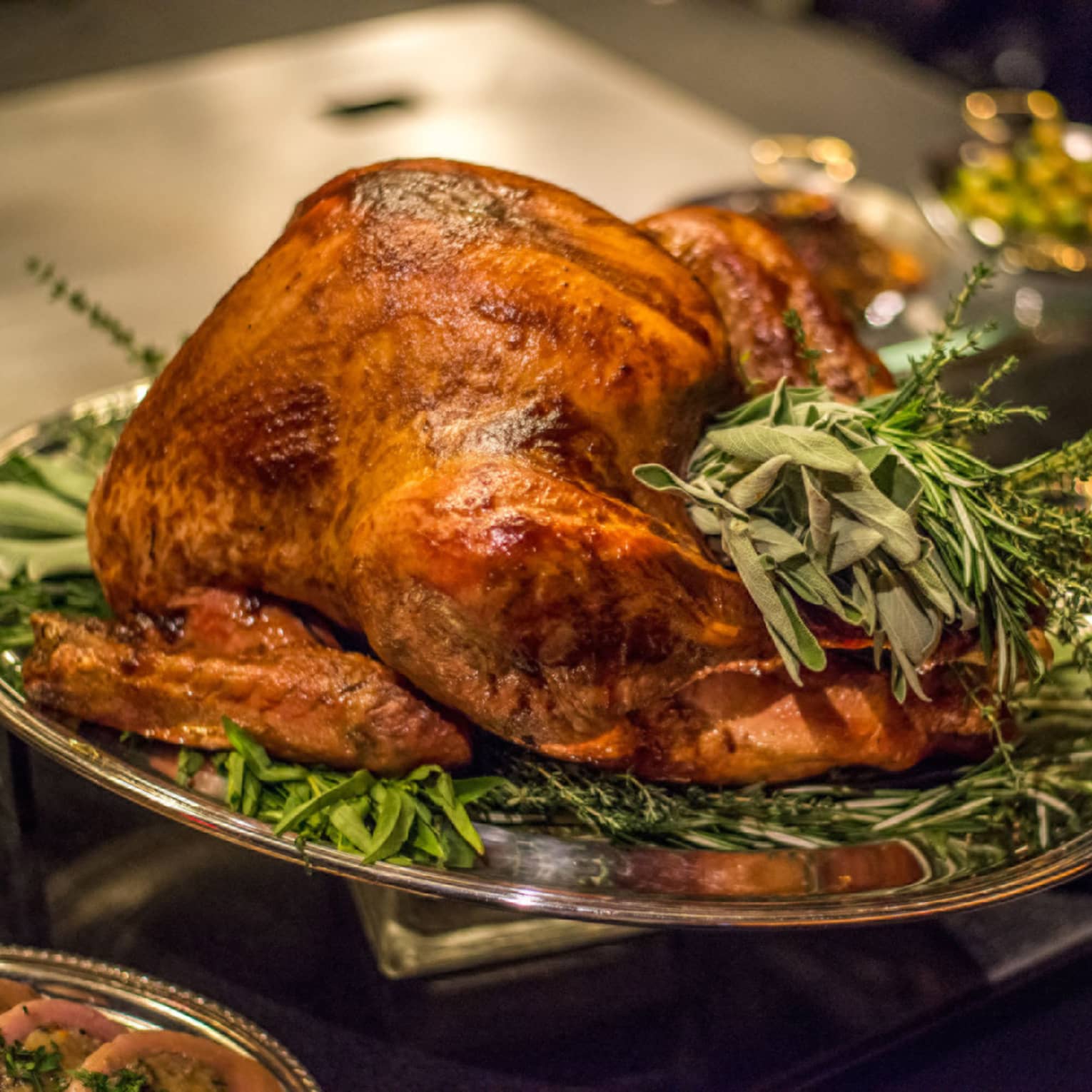 Roast turkey with fresh herbs on silver platter