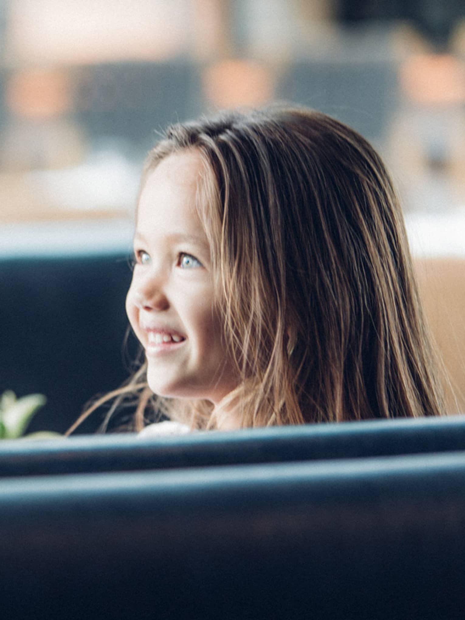 Woman in booth faces smiling, wide-eyed young girl