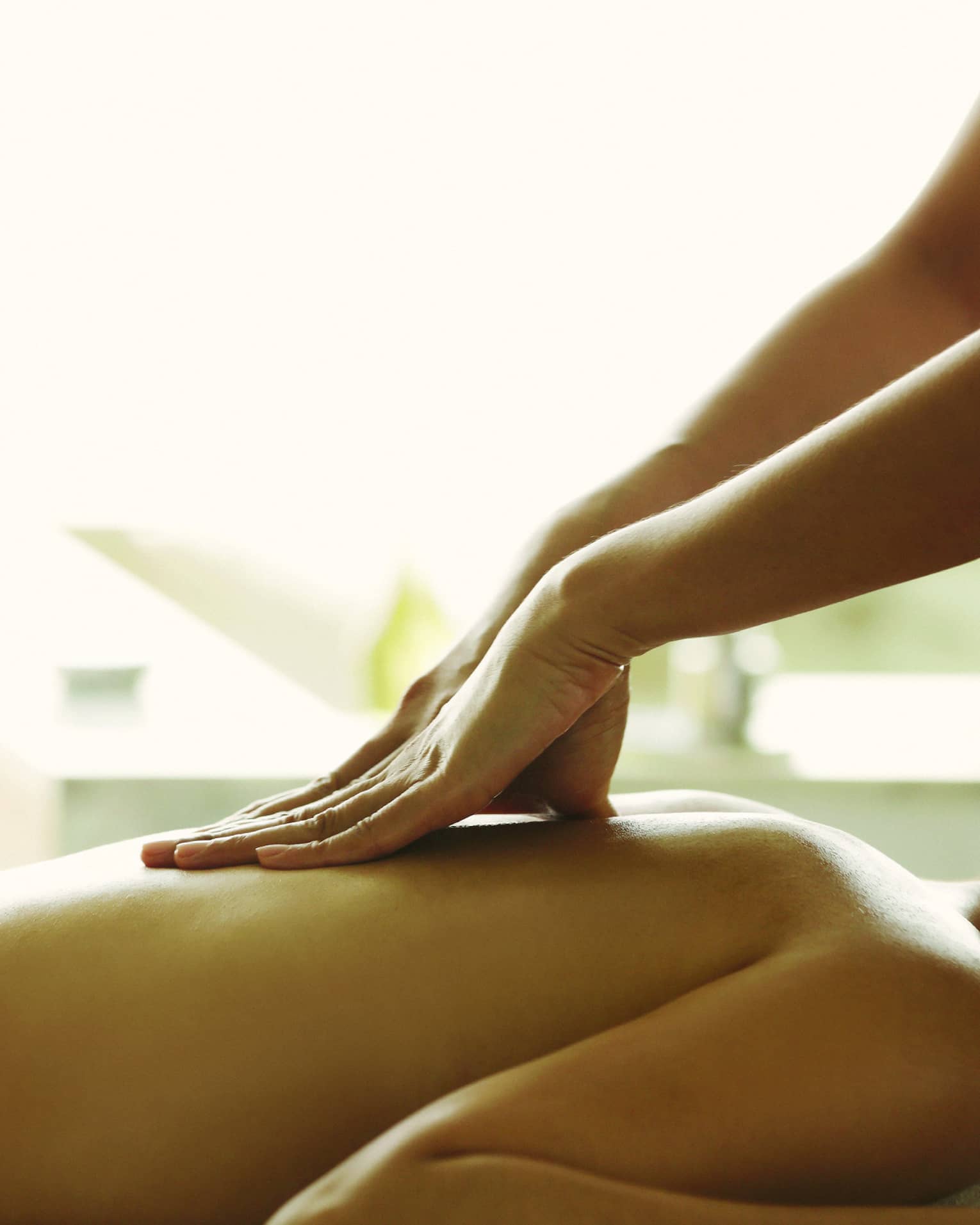 Close-up of a person receiving a relaxing back massage in a spa setting.